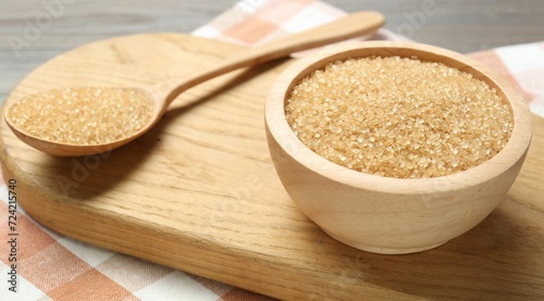 Brown sugar in bowl and spoon on table, closeup