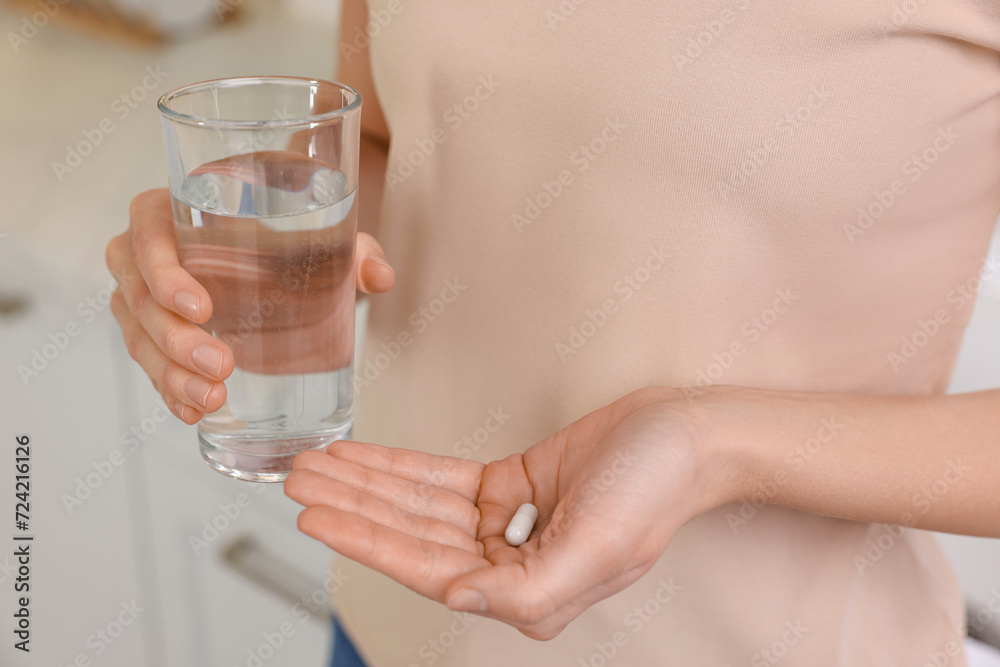 Beautiful young woman with vitamin pill and glass of water, closeup Beautiful young woman with vitamin pill and glass of water, closeup
