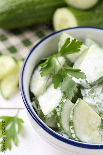 Delicious cucumber salad in bowl on table, closeup