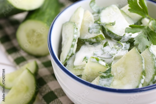 Delicious cucumber salad in bowl on table, closeup. Space for text photo