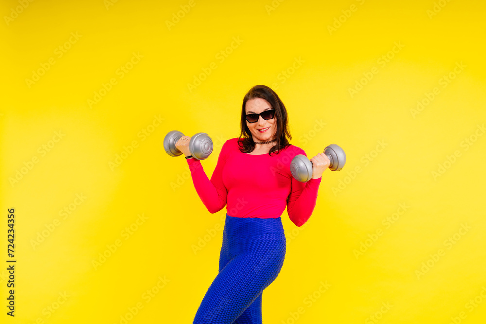 Young smiling happy chubby overweight plus size big fat fit woman warm up training hold dumbbells Young smiling happy chubby overweight plus size big fat fit woman warm up training hold dumbbells