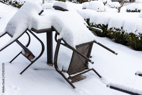 Obraz na płótnie Plastic chairs and a garden table covered with a thick layer of snow. Unprotected garden furniture for winter. w salonie