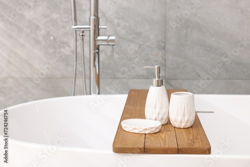 Set of bath accessories on tub in bathroom  space for text