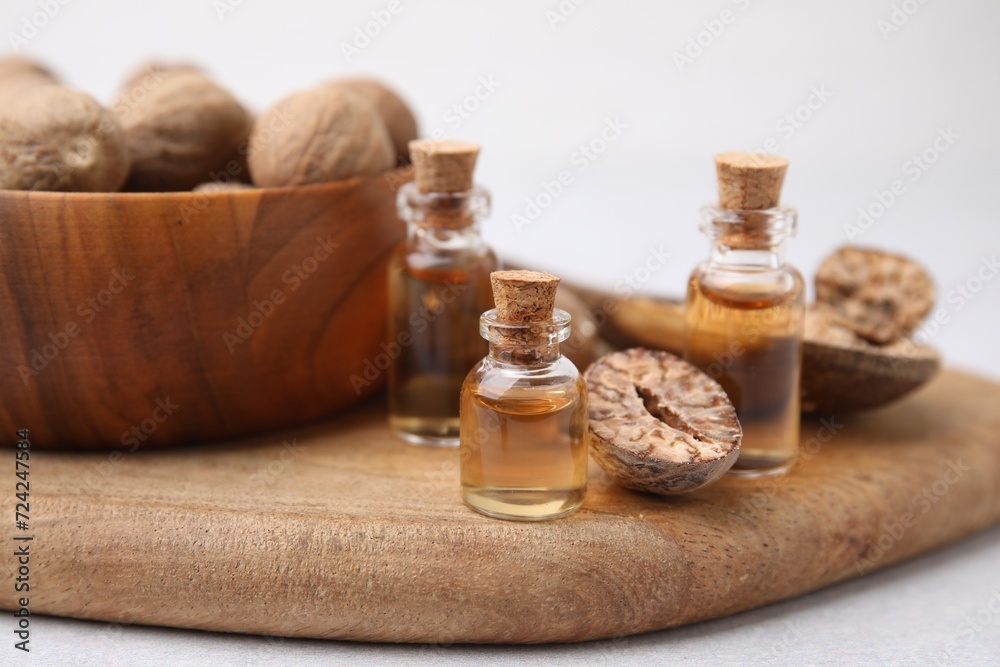 Nutmeg essential oil and nuts on light table Nutmeg essential oil and nuts on light table