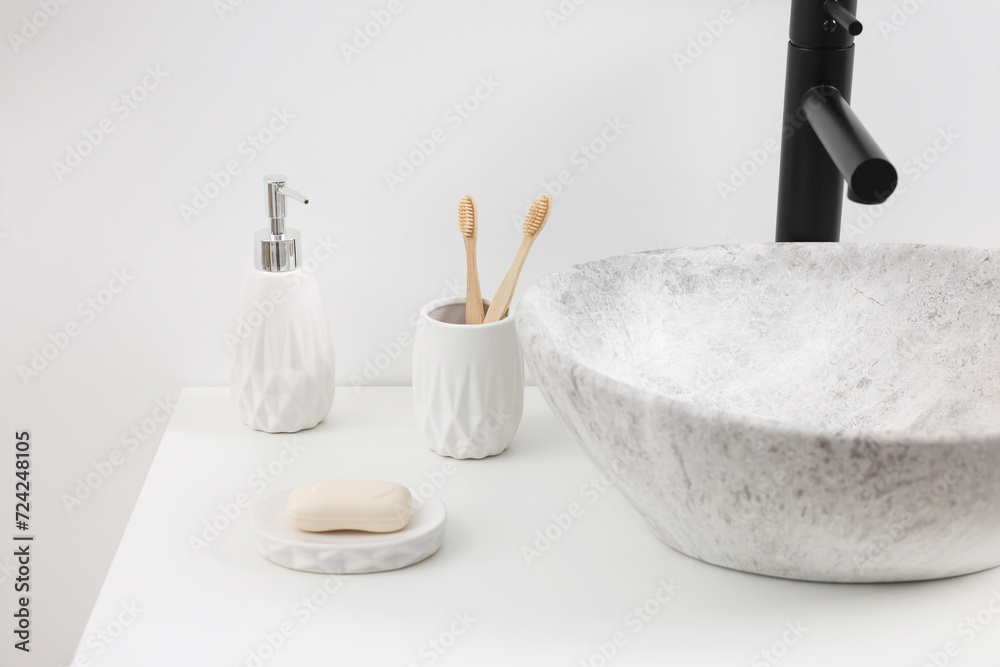 Different bath accessories and personal care products on white countertop in bathroom