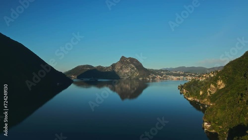 Mountains. Swiss mountains. Mountains in the river. Huge mountains. Rocks. Gandria. Lugano. Switzerland. Italy. Lake Como. City on the water's edge. Aerial shot. River. Dawn. Summer. Asia. Green