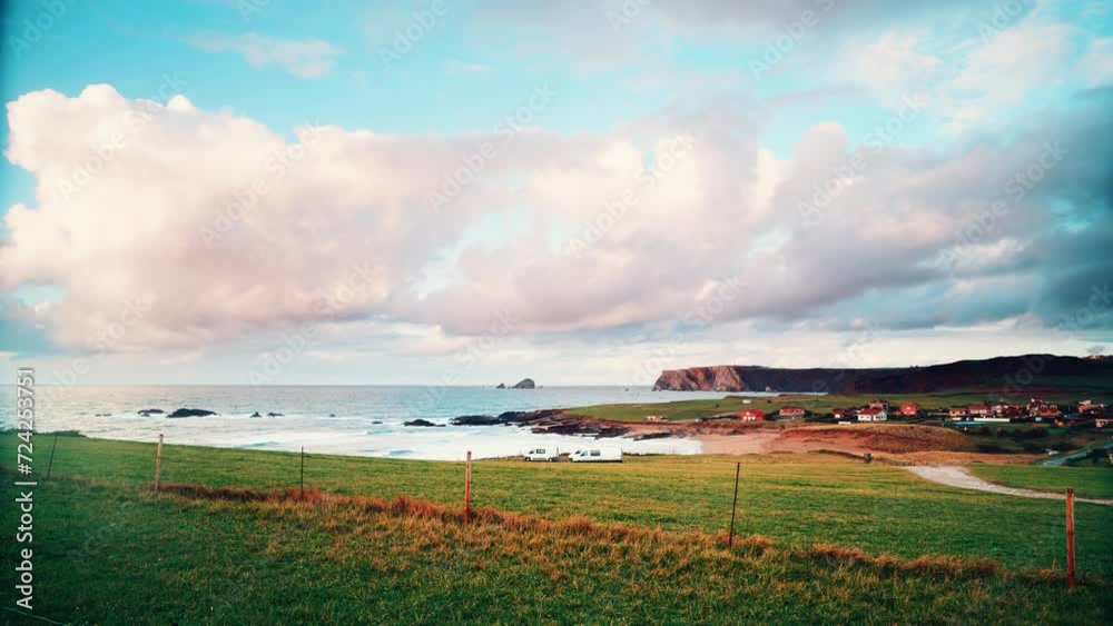 Time lapse of clouds moving over vans caravans camping on Verdicio beach and Cape Penas in the distance. Asturias coast, northern Spain. Time lapse of clouds moving over vans caravans camping on Verdicio beach and Cape Penas in the distance. Asturias coast, northern Spain.