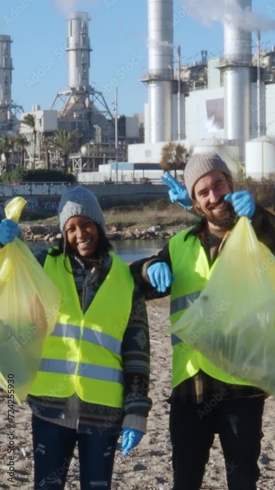 Vertical video of Portrait of happy environmentalists collecting empty bottles in plastic bags Vertical video of Portrait of happy environmentalists collecting empty bottles in plastic bags