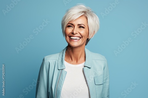 Cheerful mature woman in casual clothes looking at camera and smiling