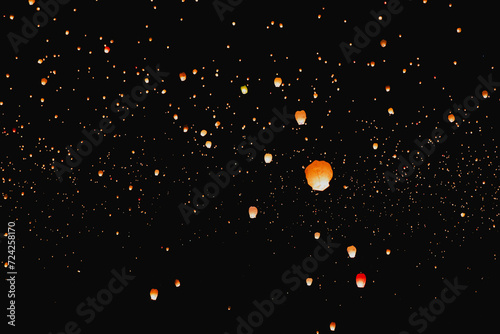 Night sky filled with glowing floating lanterns photo