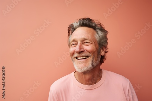 Portrait of a smiling senior man on a pink background. Copy space.