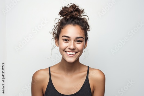 Joyful young woman with a bun hairstyle, on a white background