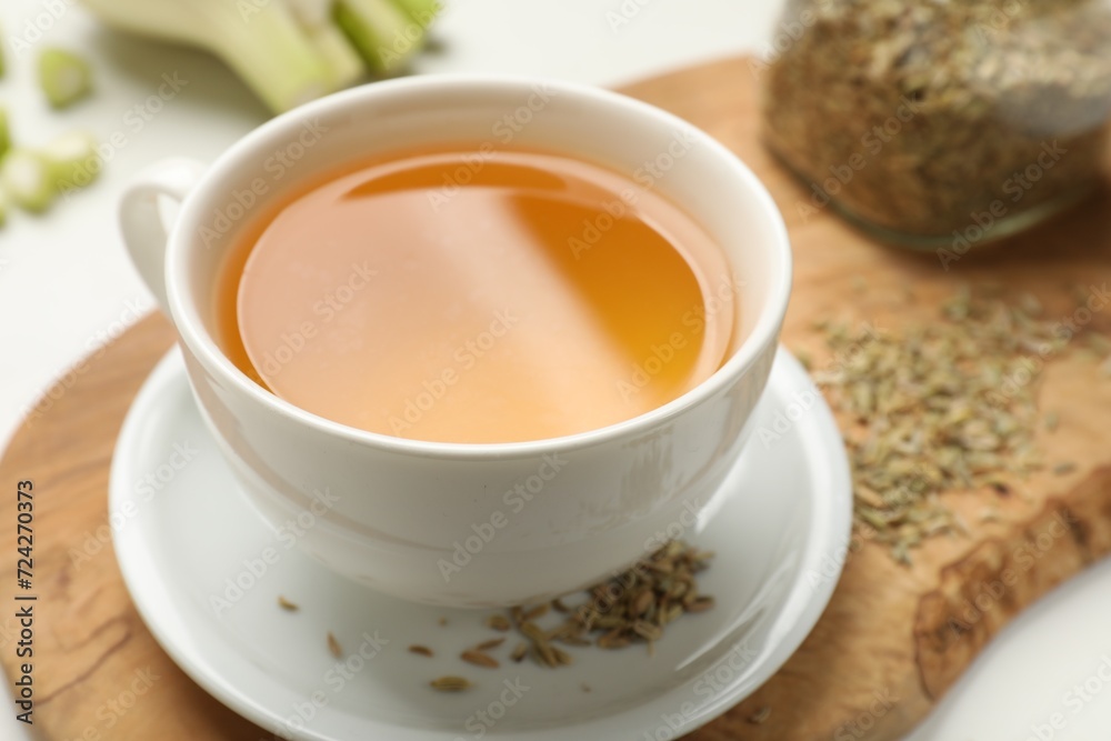Fennel tea in cup and seeds on white table, closeup Fennel tea in cup and seeds on white table, closeup