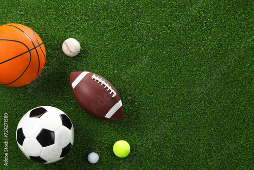 Many different sports balls on green grass  flat lay. Space for text