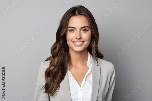 Portrait of happy smiling young business woman, over grey background.