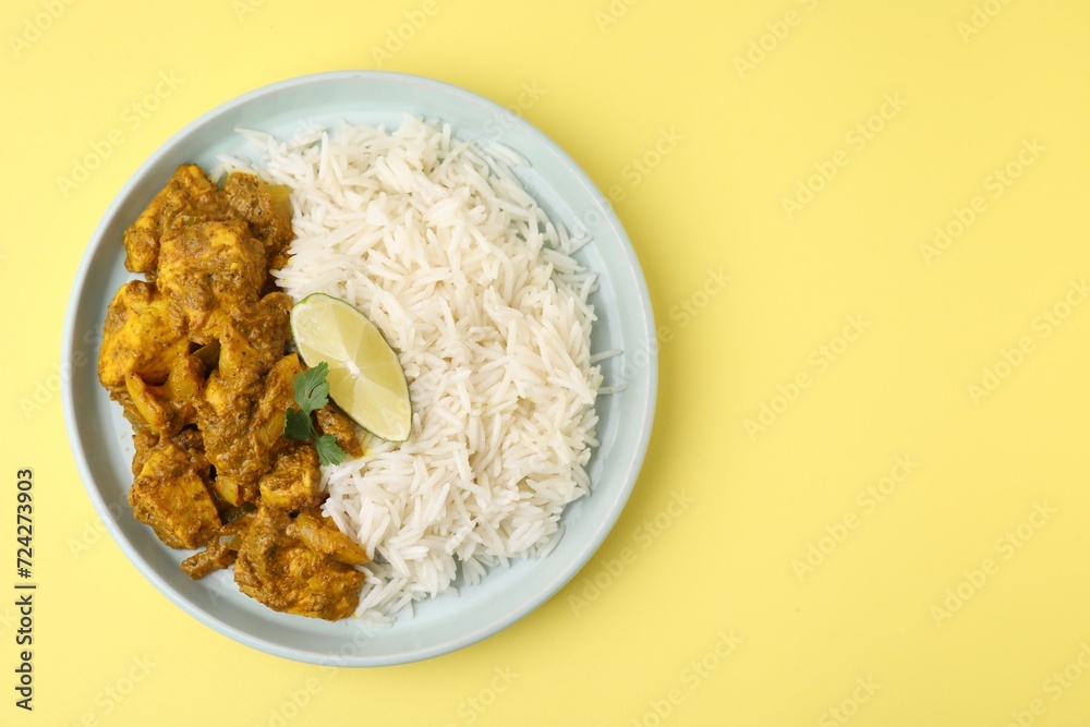 Delicious chicken curry with rice on yellow background, top view. Space for text Delicious chicken curry with rice on yellow background, top view. Space for text