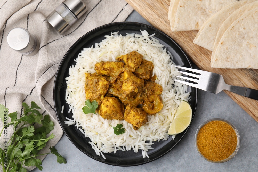 Delicious chicken curry with rice and ingredients on grey table, flat lay Delicious chicken curry with rice and ingredients on grey table, flat lay