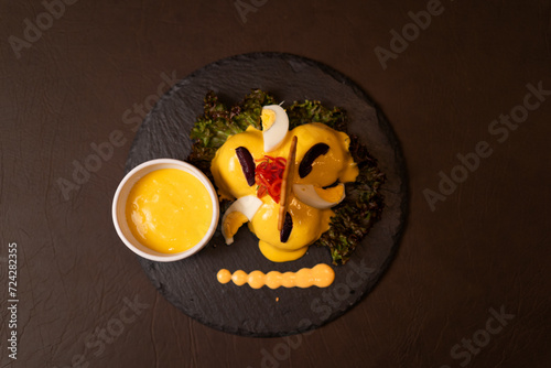 Foto Plato de papas a la huancaína en fondo oscuro