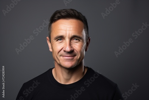 Portrait of a happy mature man smiling at the camera over grey background.