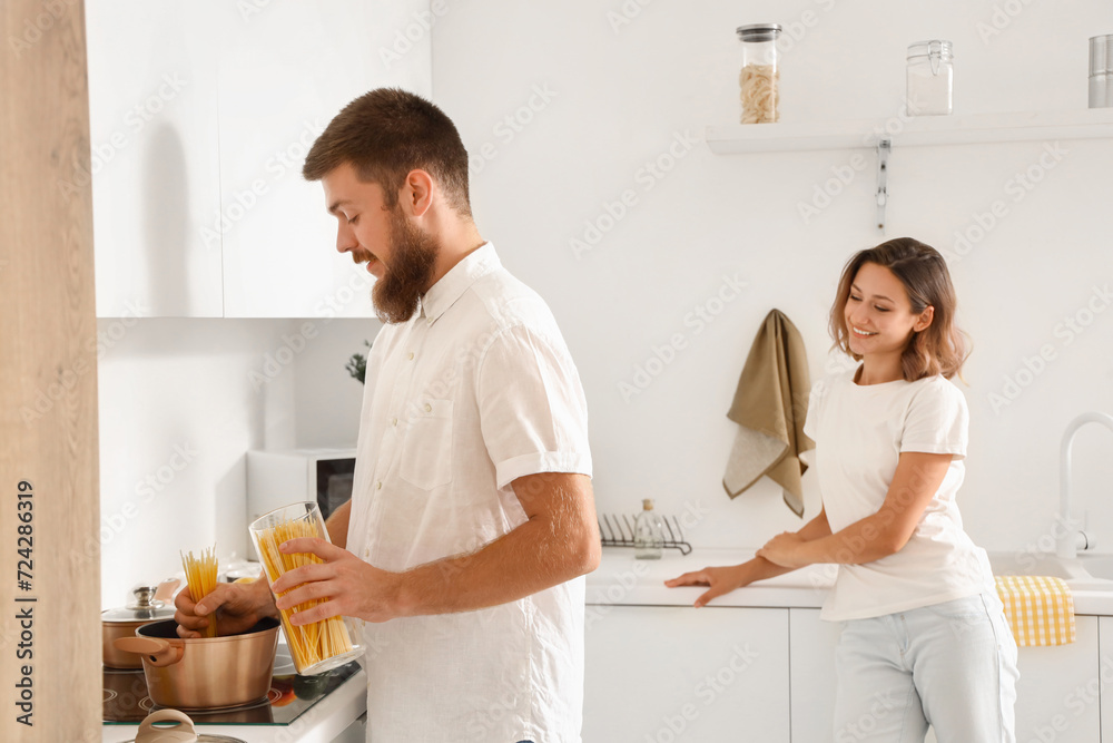 Fototapeta premium Happy couple in love boiling pasta in kitchen