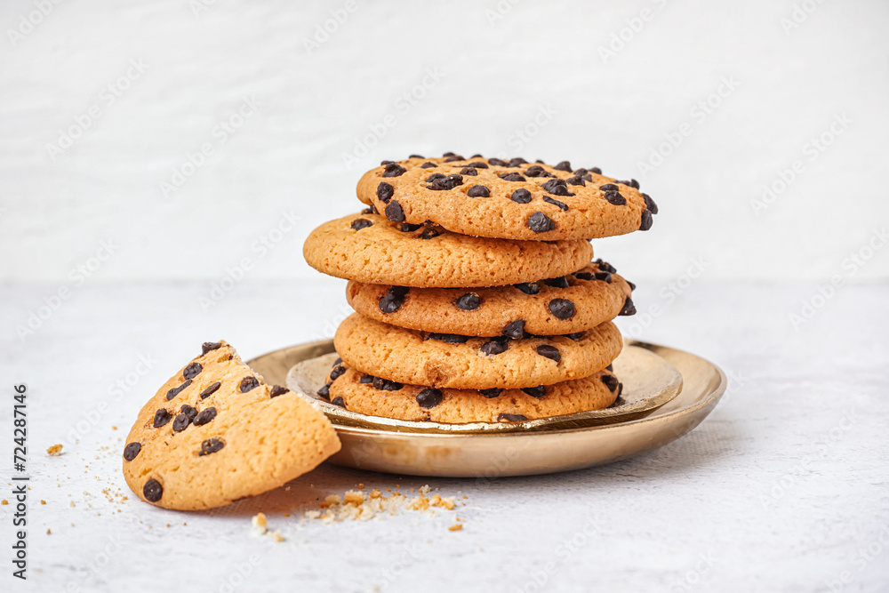 Plates of tasty cookies with chocolate chips on white background