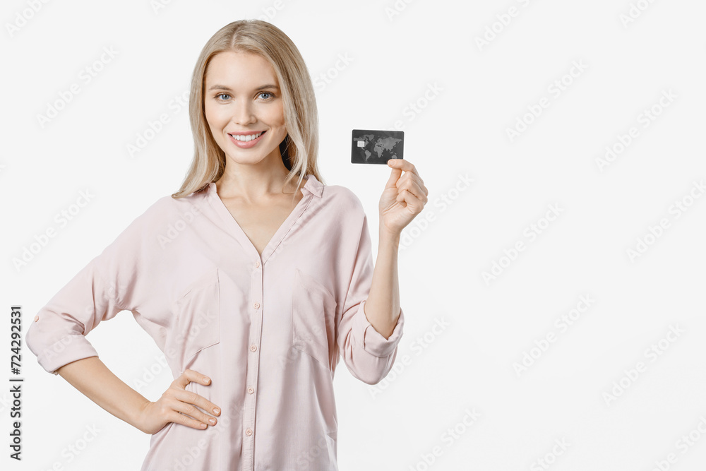 Happy young woman holding and showing credit card over white background. Concept of online shopping remote purchases, e-baking e-commerce loan Happy young woman holding and showing credit card over white background. Concept of online shopping remote purchases, e-baking e-commerce loan