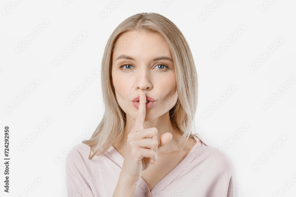 Portrait of attractive girl with finger on lips isolated over white background. Top secret, silent gesture. Woman with emotion looking at camera Portrait of attractive girl with finger on lips isolated over white background. Top secret, silent gesture. Woman with emotion looking at camera