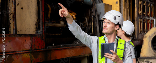 Young caucasian engineer man and woman checking train with tablet in station, team engineer inspect system transport, technician examining infrastructure, transportation and industry.