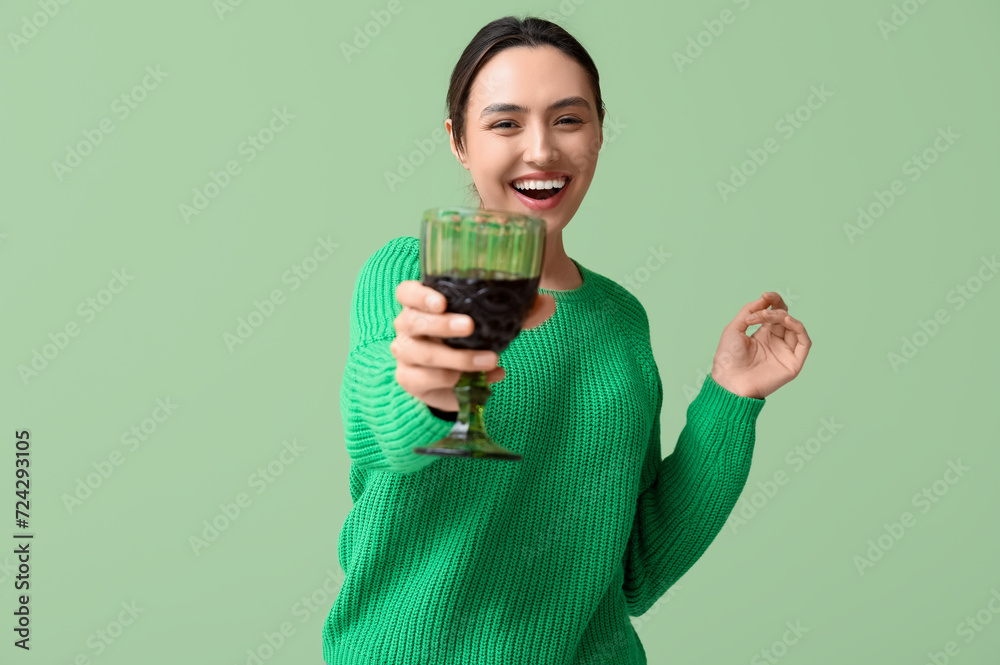 Beautiful young woman with glass of red wine on green background Beautiful young woman with glass of red wine on green background