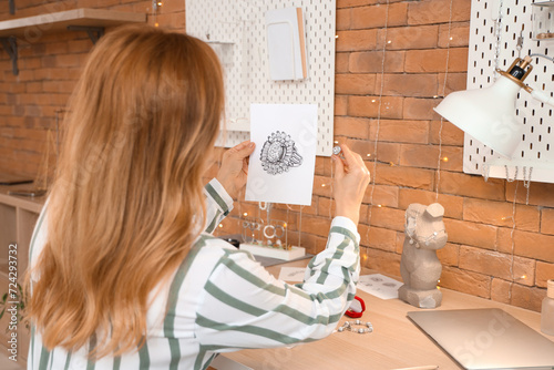 Female jeweler with sketch ...