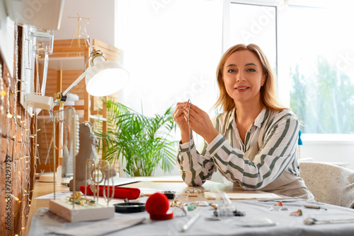 Female jeweler examining ea...