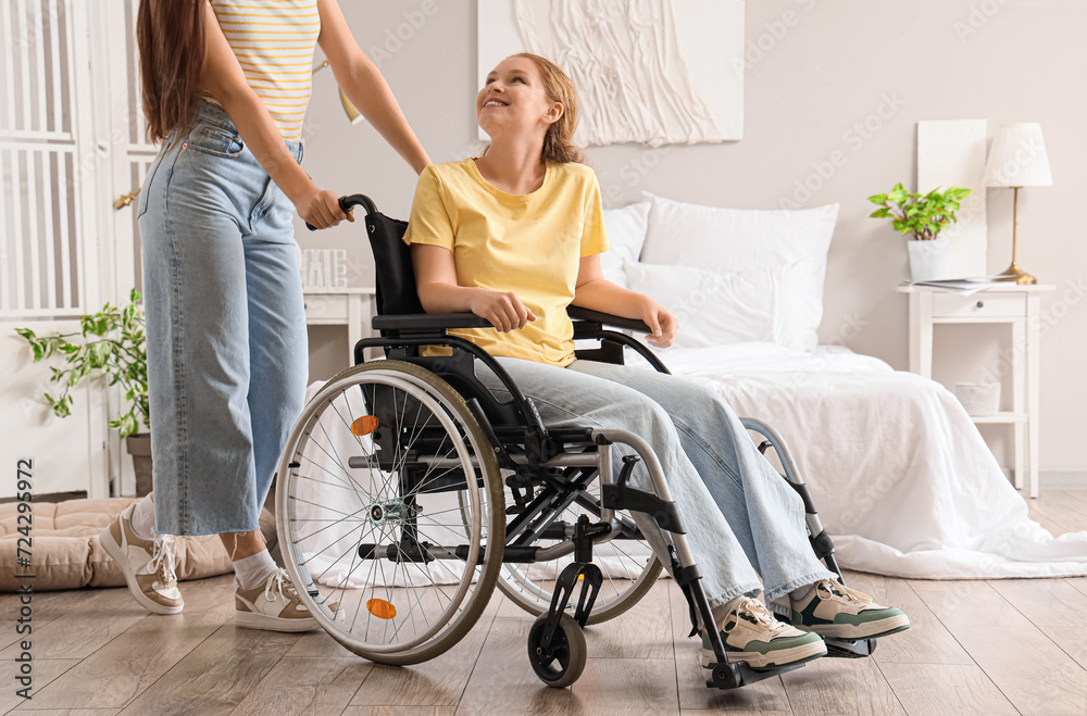 Young redhead woman in wheelchair with her friend at home Young redhead woman in wheelchair with her friend at home