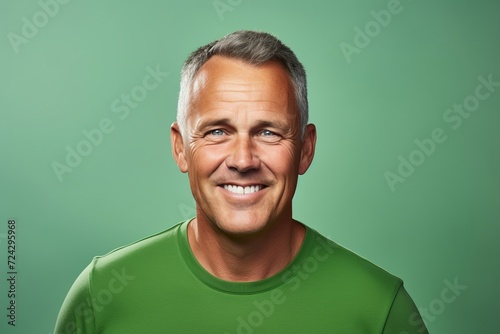 Portrait of smiling senior man over green background. Looking at camera.