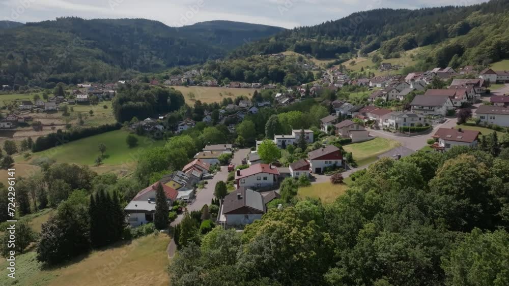 Aerial view of quaint houses and lush greenery in a German village during summer - orbital drone cinematic movement Aerial view of quaint houses and lush greenery in a German village during summer - orbital drone cinematic movement