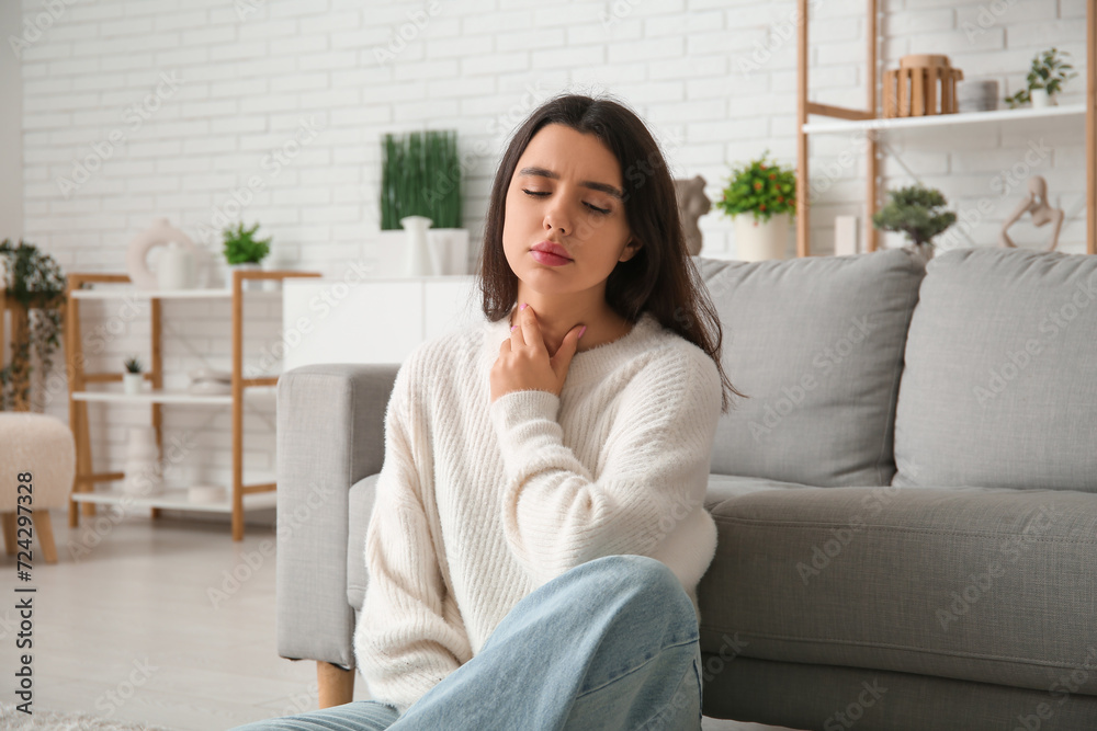 Young woman suffering from thyroid gland problem at home Young woman suffering from thyroid gland problem at home