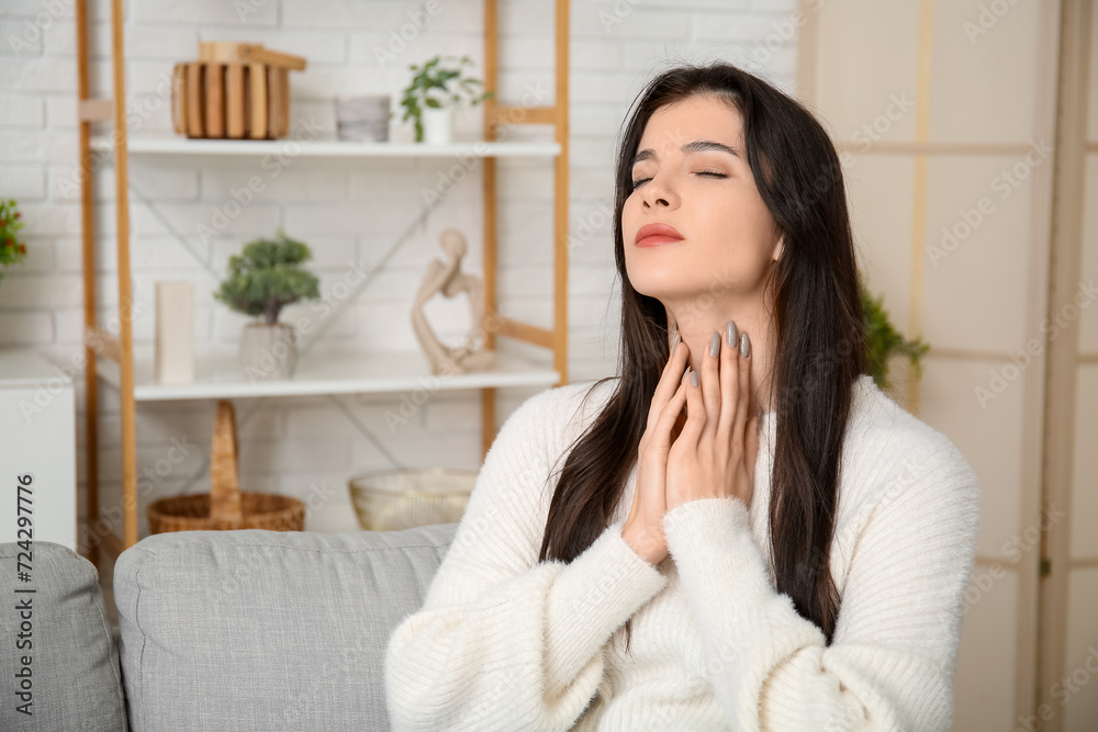 Young woman suffering from thyroid gland problem at home Young woman suffering from thyroid gland problem at home