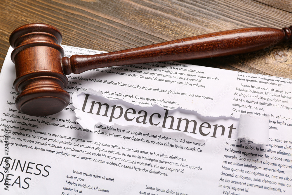 Newspapers with word IMPEACHMENT and judge gavel on wooden background, closeup Newspapers with word IMPEACHMENT and judge gavel on wooden background, closeup