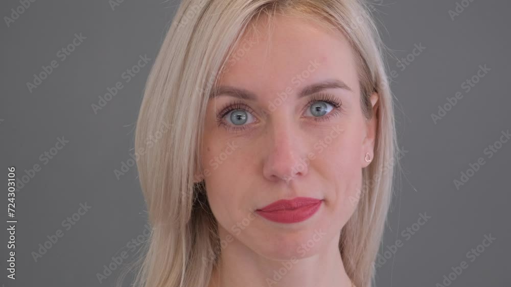 Portrait of a beautiful blonde on a gray background in the studio. Slow motion Portrait of a beautiful blonde on a gray background in the studio. Slow motion