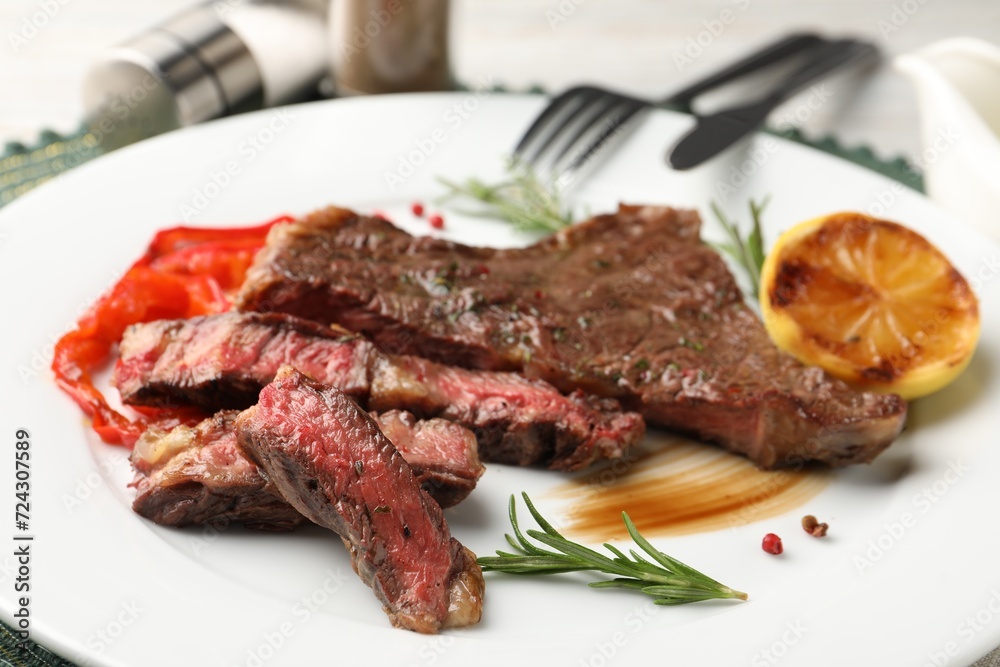 Delicious grilled beef steak with spices on plate, closeup