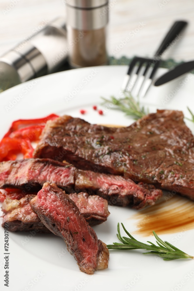 Delicious grilled beef steak with spices on plate, closeup