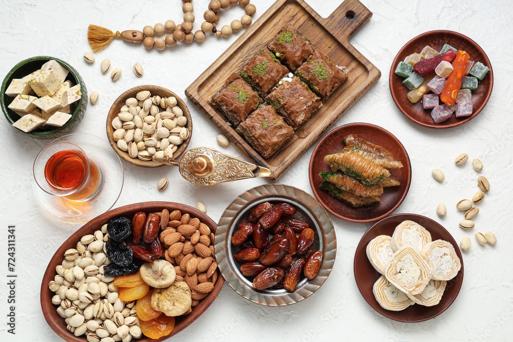 Composition with traditional Eastern sweets, tasbih and Aladdin lamp for Ramadan on light background Composition with traditional Eastern sweets, tasbih and Aladdin lamp for Ramadan on light background