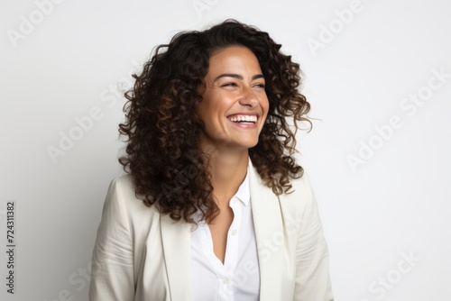 Portrait of beautiful young woman with curly hair smiling against white background