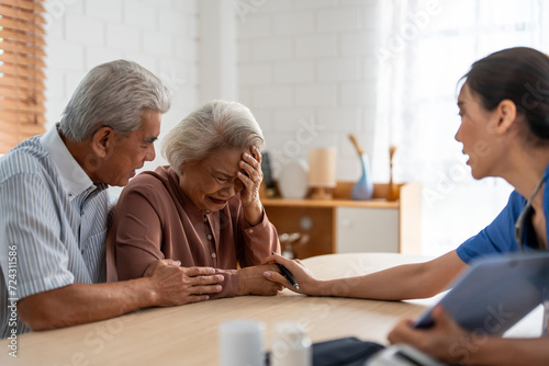 Asian caregiver examine depress senior crying woman patient and husband. 