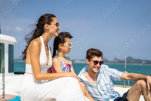Caucasian happy family sitting on deck of yacht while yachting outdoor.  © Kawee