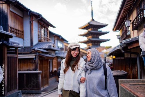 Travel, muslim travel, woman girl tourist Two Asian friends but different religions walking at Yasaka Pagoda and Sannen Zaka Street in Kyoto Japan, Yasaka Pagoda is the famous landmark and travel.