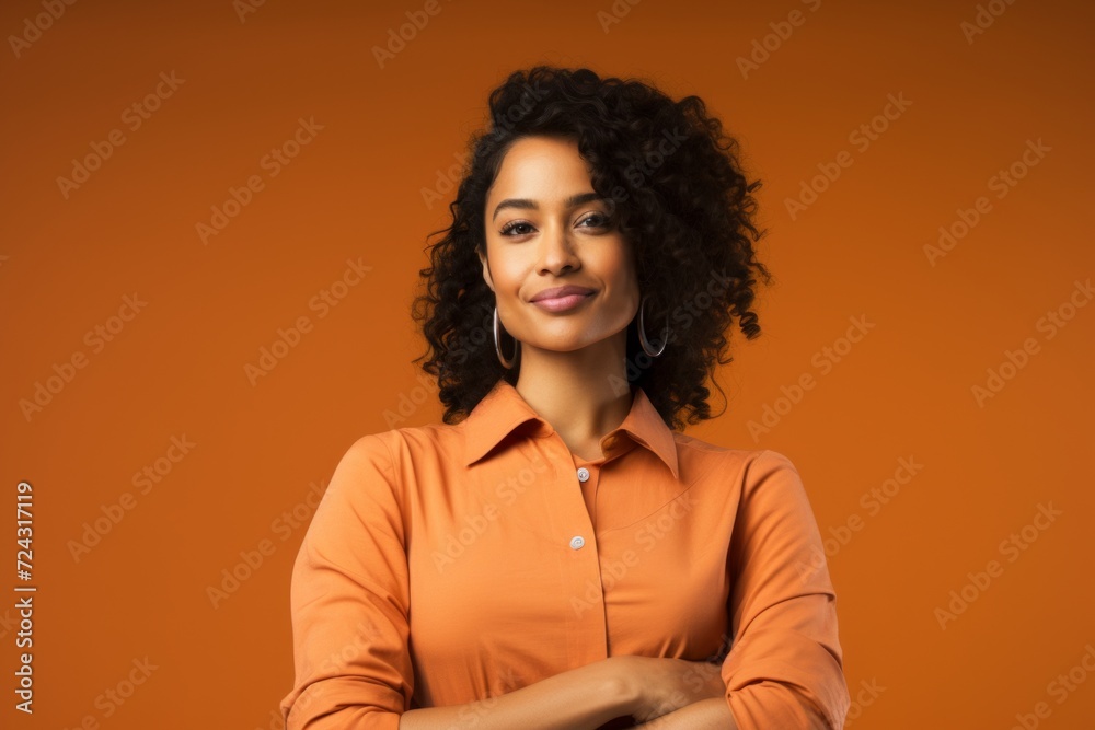 smiling african american woman in orange shirt on orange background smiling african american woman in orange shirt on orange background