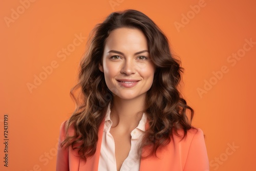 Portrait of a beautiful young brunette woman on orange background.