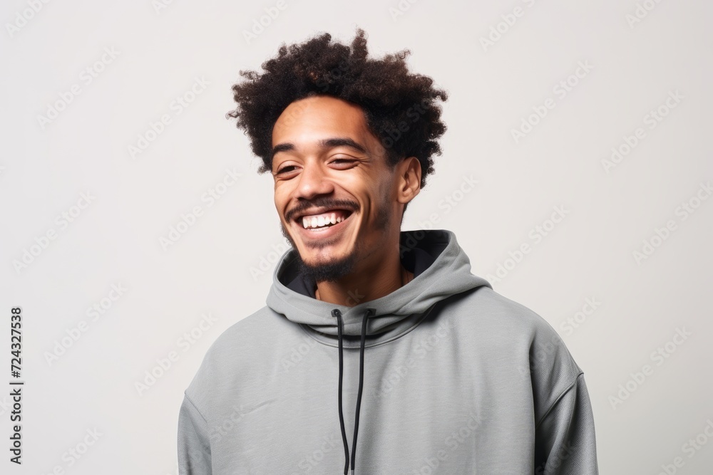 Portrait of a young african american man laughing over gray background