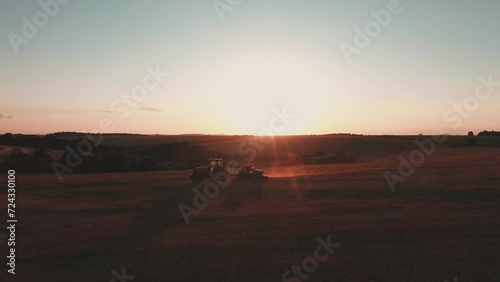 a tractor pulling a planter at sunset