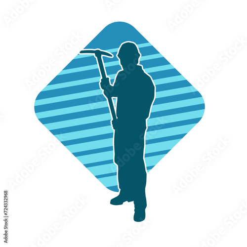 Silhouette of a man in worker costume carrying pick axe tool in action pose. Silhouette of a miner in action pose with pick axe tool.